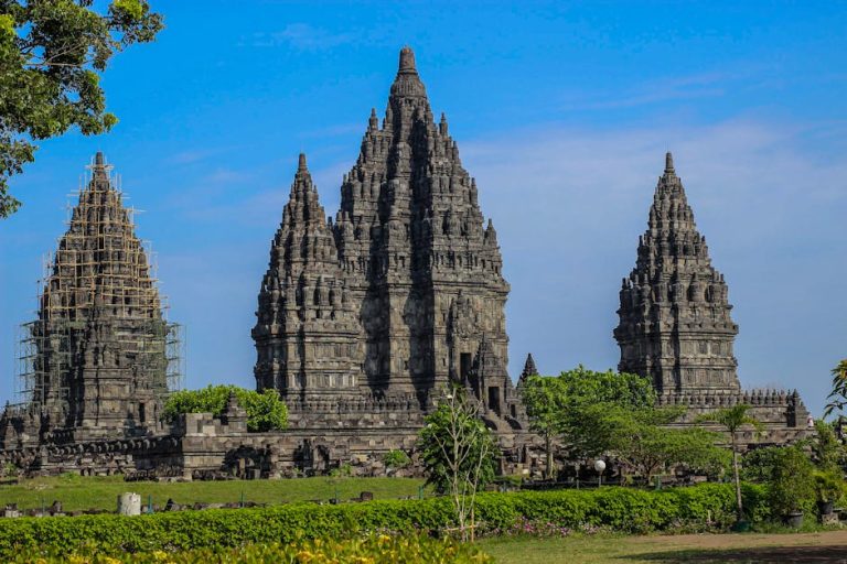 Explore the stunning architecture of Prambanan Temple against a clear blue sky in Indonesia.